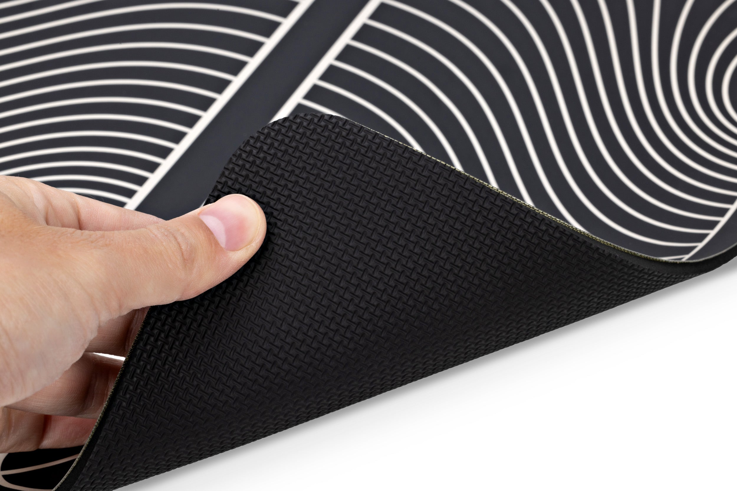 TENS Comfee foot pad accessory. Black and white stripped. A hand is holding up to show the non slip underside.